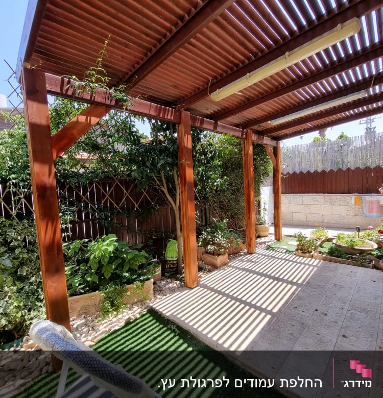 גינה עם פרגולה מעץ וצמחים בעציצים